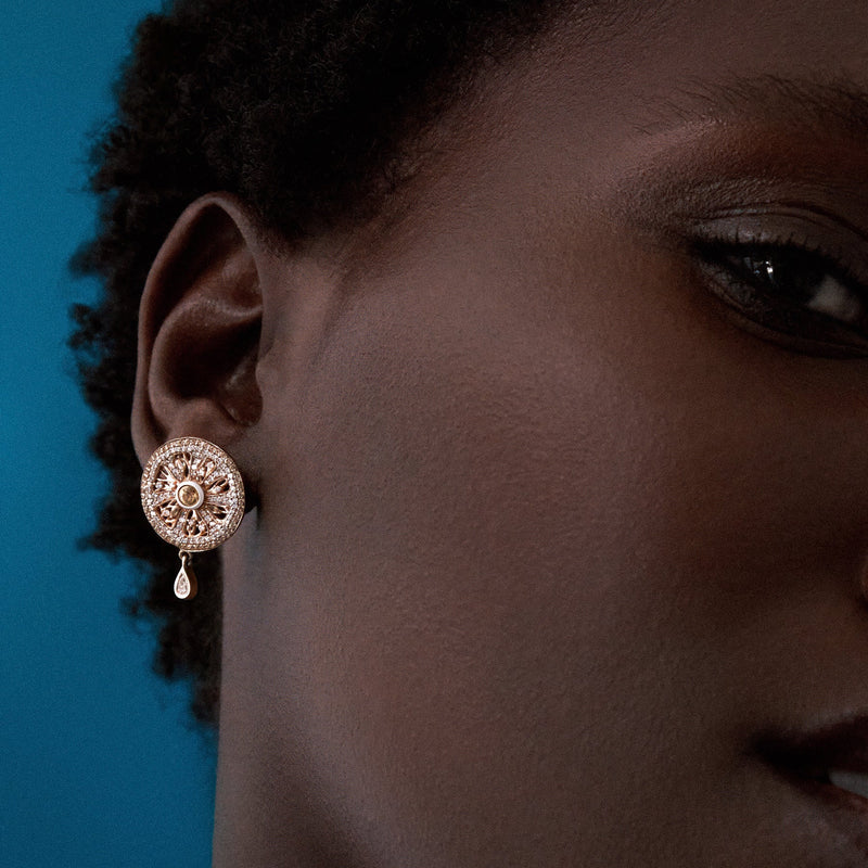 close up of zest earring on model in 14k yellow gold with diamonds and yellow sapphires by cocoerow fine jewelry